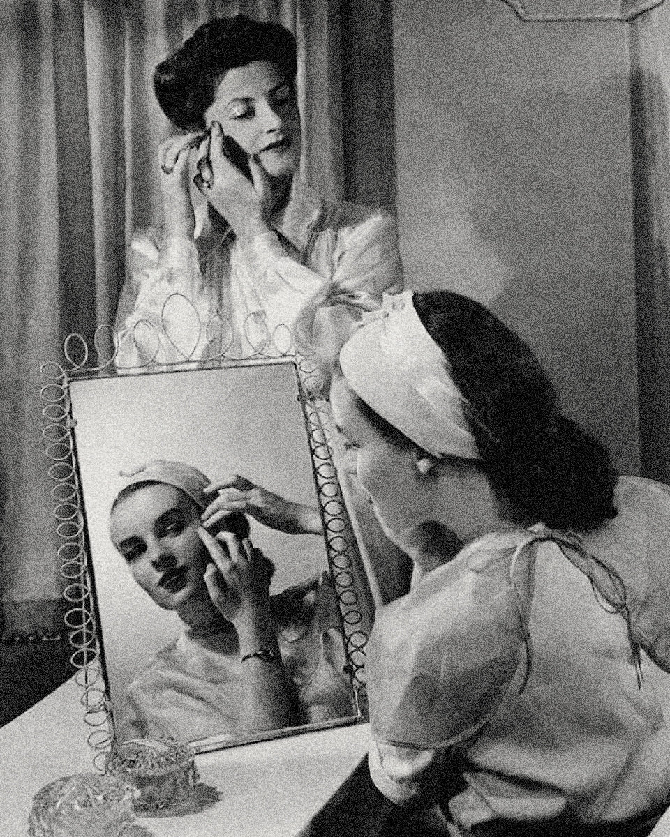 A woman at her dressing table applying skincare